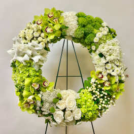 Large green and white floral wreath on a stand