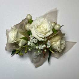 White rose corsage with small white berries and gold ribbon