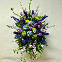 Tall standing floral spray with purple, blue, and green flowers