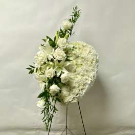 White floral standing spray with roses and lilies on an easel