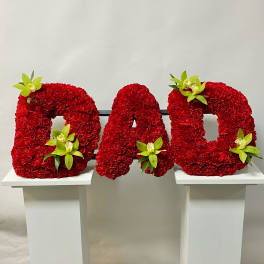 Red floral letters spelling DAD with green orchid accents