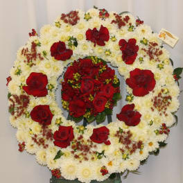 Heart-shaped floral wreath of white chrysanthemums and red roses