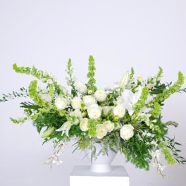 White floral arrangement in a white pedestal vase