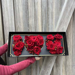 Red roses arranged in a black rectangular gift box