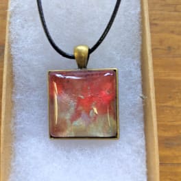 Square red pendant necklace on a black cord in a gift box