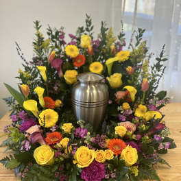 Colorful floral wreath around a silver urn centerpiece