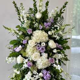 Large standing floral spray with white, lavender, and cream blooms