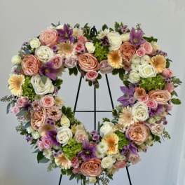Heart-shaped floral wreath with pink, white, purple, and peach blooms