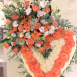 Heart-shaped floral spray with orange and white roses