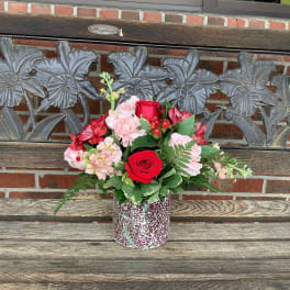 Red and pink flower arrangement in a mosaic vase