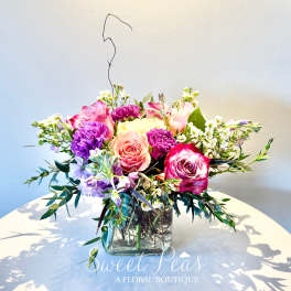 Mixed pink and purple bouquet in a square glass vase