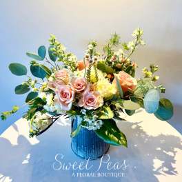 Pink roses and white flowers arranged in a blue vase