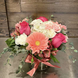 Pink and white mixed flower arrangement in a glass vase with ribbon