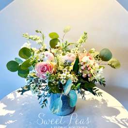 Pink roses and white blossoms arranged in a blue vase