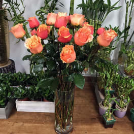 Bouquet of peach and coral roses in a clear glass vase