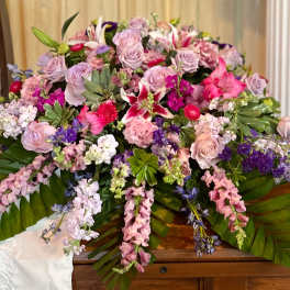 Large pink and lavender floral casket spray with lilies and roses