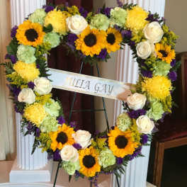 Heart-shaped floral wreath with sunflowers, white roses, and purple accents