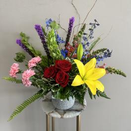 Colorful mixed flower arrangement in a patterned vase