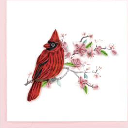 Quilled paper cardinal perched on a branch of pink blossoms on a white greeting card