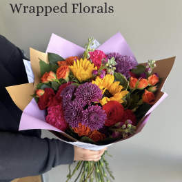 Wrapped bouquet of mixed flowers in purple and brown paper