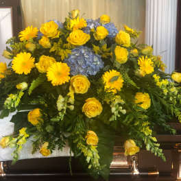 Yellow roses and daisies with blue hydrangea in a casket spray