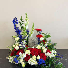 Red and white roses with blue and white flowers in a low centerpiece
