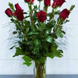 Tall bouquet of red roses in a clear glass vase
