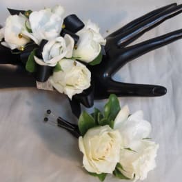 White rose corsage and boutonniere with black ribbon accents
