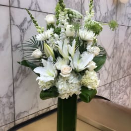 White floral arrangement in a tall green vase