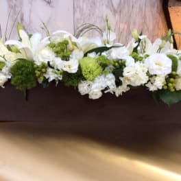 White floral arrangement in a rectangular brown container