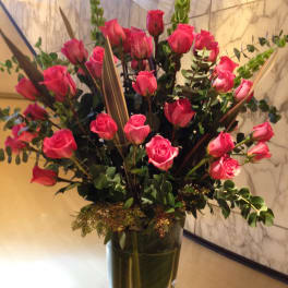 Tall bouquet of pink roses in a clear glass vase