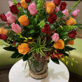 Mixed rose arrangement in a decorative glass vase