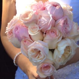 Bride holding a bouquet of pale pink and ivory roses