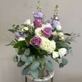 Lavender and white floral arrangement in a vase with trailing eucalyptus