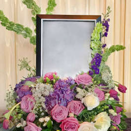Floral frame arrangement with pink and white roses around a blank center panel