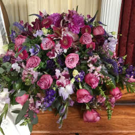 Large bouquet of pink and purple flowers on a wooden table