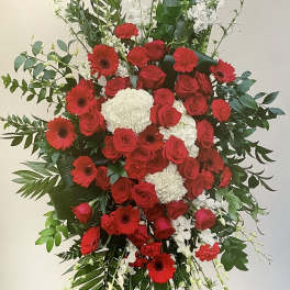 Large standing floral spray with red roses, red gerbera daisies, and white blooms