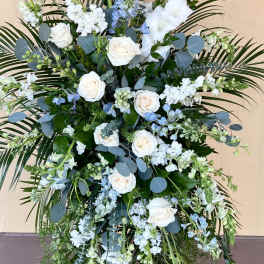 Tall white and blue floral standing spray on an easel