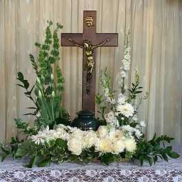White floral arrangement with a crucifix centerpiece