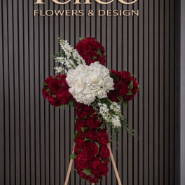 Red and white floral cross on a wooden stand