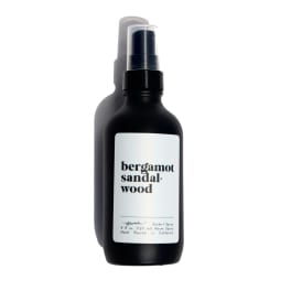 Matte black spray bottle with a white label reading bergamot sandalwood.