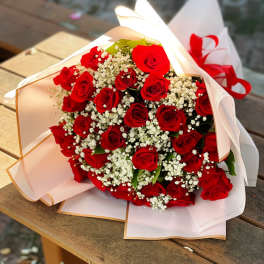 Bouquet of red roses with white baby's breath in white wrapping