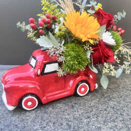 Red truck planter filled with mixed flowers and greenery
