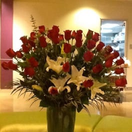 Tall vase arrangement of red roses and white lilies