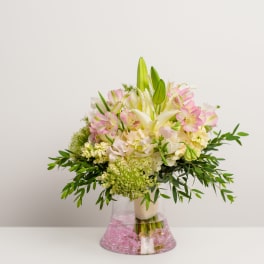 Pink and white bouquet with lilies in a clear vase