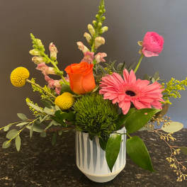 Mixed bouquet in a white vase with pink and orange blooms