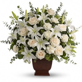 White lilies and cream roses arranged in a brown urn vase
