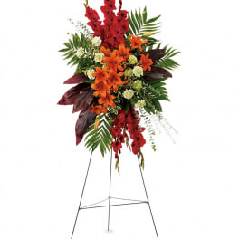 Tall standing floral spray with red and orange flowers on a metal easel