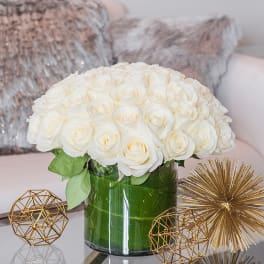 White rose bouquet in a green glass vase with gold decor