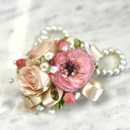 Small pink and blush floral corsage with ribbon and pearl accents